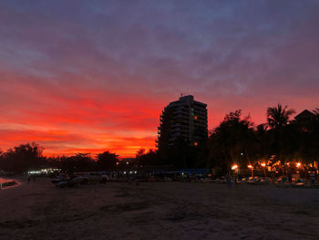 Illuminated buildings against sky at sunset