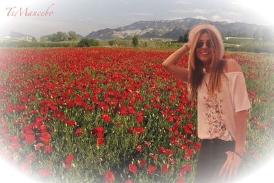 Woman smelling flowers growing in field