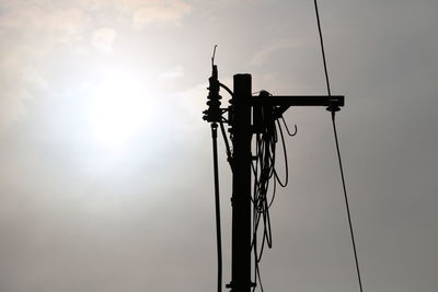 Low angle view of silhouette pole against sky