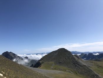 Scenic view of mountains against blue sky