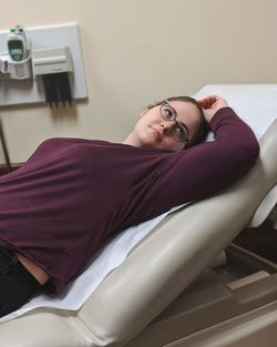 Portrait of young woman lying on hospital bed