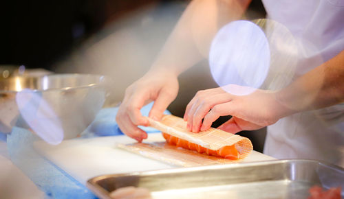 Midsection of man preparing food on cutting board