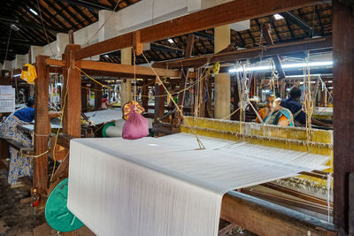 Women work in an old loom weaving cooperative in kannur, kerala, india