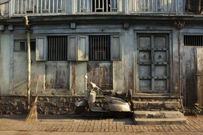 Man sitting on sidewalk against building