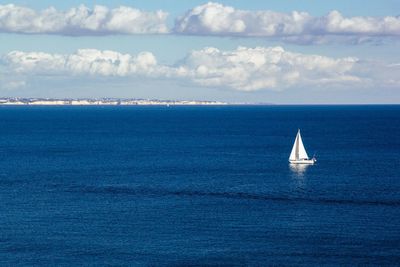 Sailboat on sea against blue sky