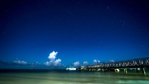 Low angle view of bridge against blue sky at night