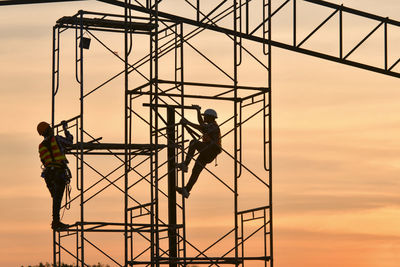 Silhouette electricity pylon against sky during sunset
