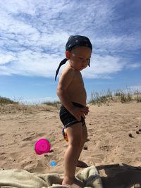 Full length of shirtless boy on sand