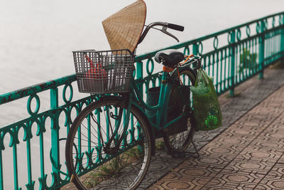 Bicycle parked by railing on footpath