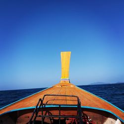 Built structure by sea against clear blue sky