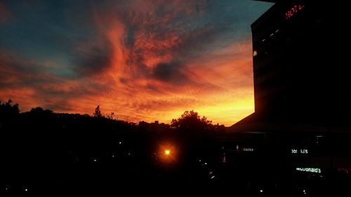 Silhouette city against sky at sunset