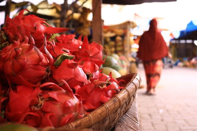 Close-up of red flowers in basket for sale