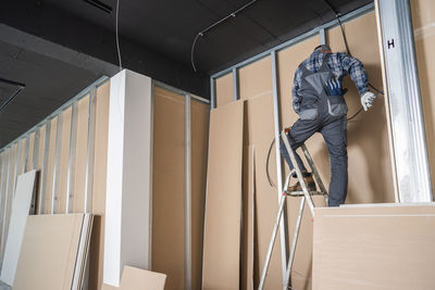 Side view of man standing against building