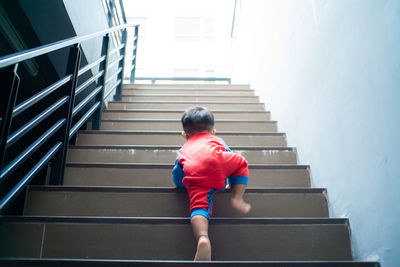 Rear view of boy moving up on staircase
