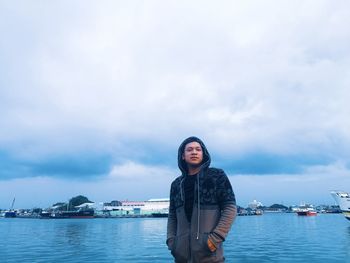 Portrait of young man standing against sea