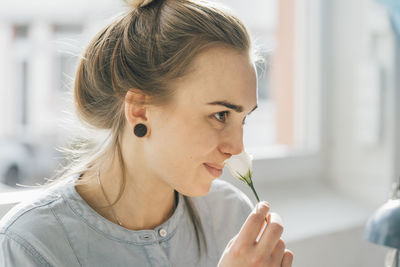 Smiling young woman smelling blossom