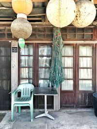 Empty chairs and table against building