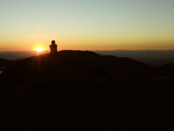 Silhouette mountain against clear sky during sunset