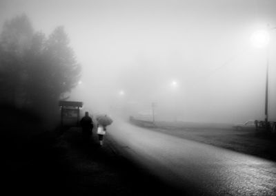 Woman walking on road at night