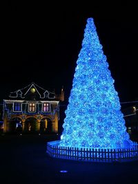 Illuminated christmas tree against clear sky at night