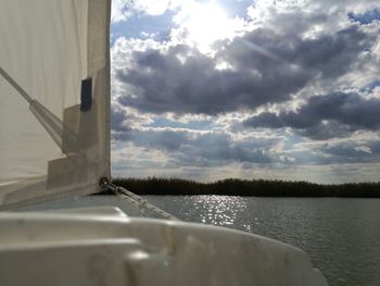 Close-up of boat sailing in lake against sky