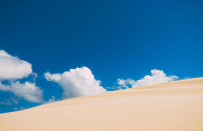 Low angle view of desert against blue sky