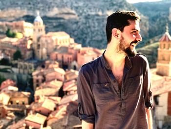 Portrait of young man standing against albarracín cityscape