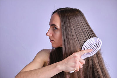 Midsection of young woman wearing hat against white background