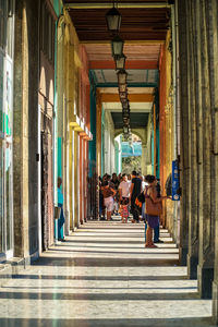 Rear view of people walking in tunnel