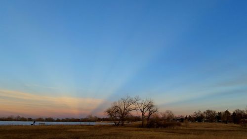 Scenic view of field against sky at sunset