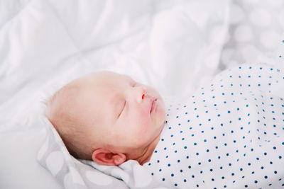 Close-up of baby lying on bed