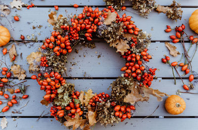 Top view of handmade colorful floral autumn door wreath made of colorful rosehip berries, rowan