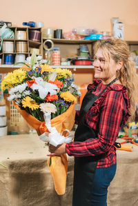 Midsection of woman holding flower bouquet