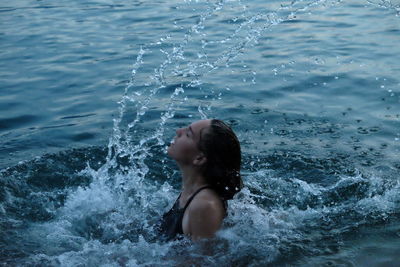 Full length of shirtless girl swimming in pool