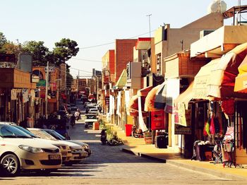 Cars on street in city against clear sky