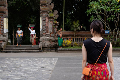 Rear view of women walking on street in temple