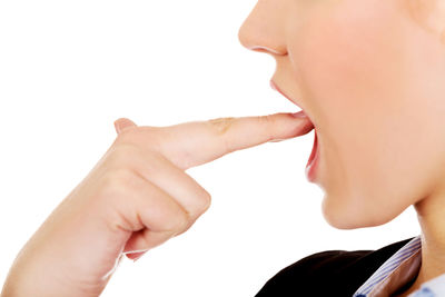 Close-up of woman holding hands over white background
