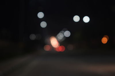 Defocused image of illuminated lights in city at night