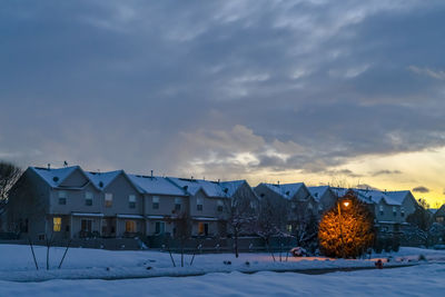 Houses and buildings against sky during winter