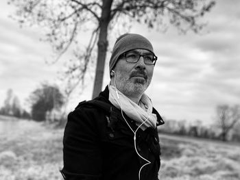 Man listening music against trees