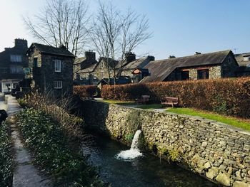 River amidst houses and buildings against clear sky