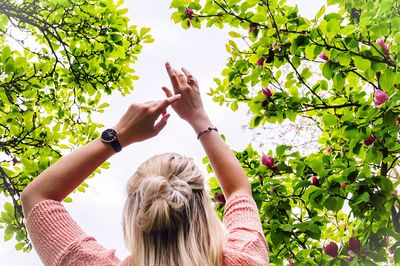 Low angle view of woman against tree