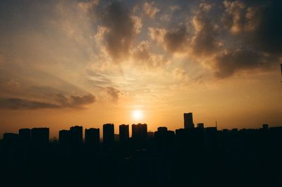 Silhouette buildings against sky during sunset