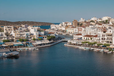 Aerial view of townscape by sea against clear sky
