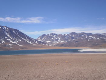 Scenic view of lake and mountains against cloudy sky