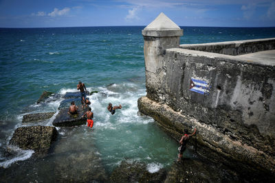 People at sea shore against sky