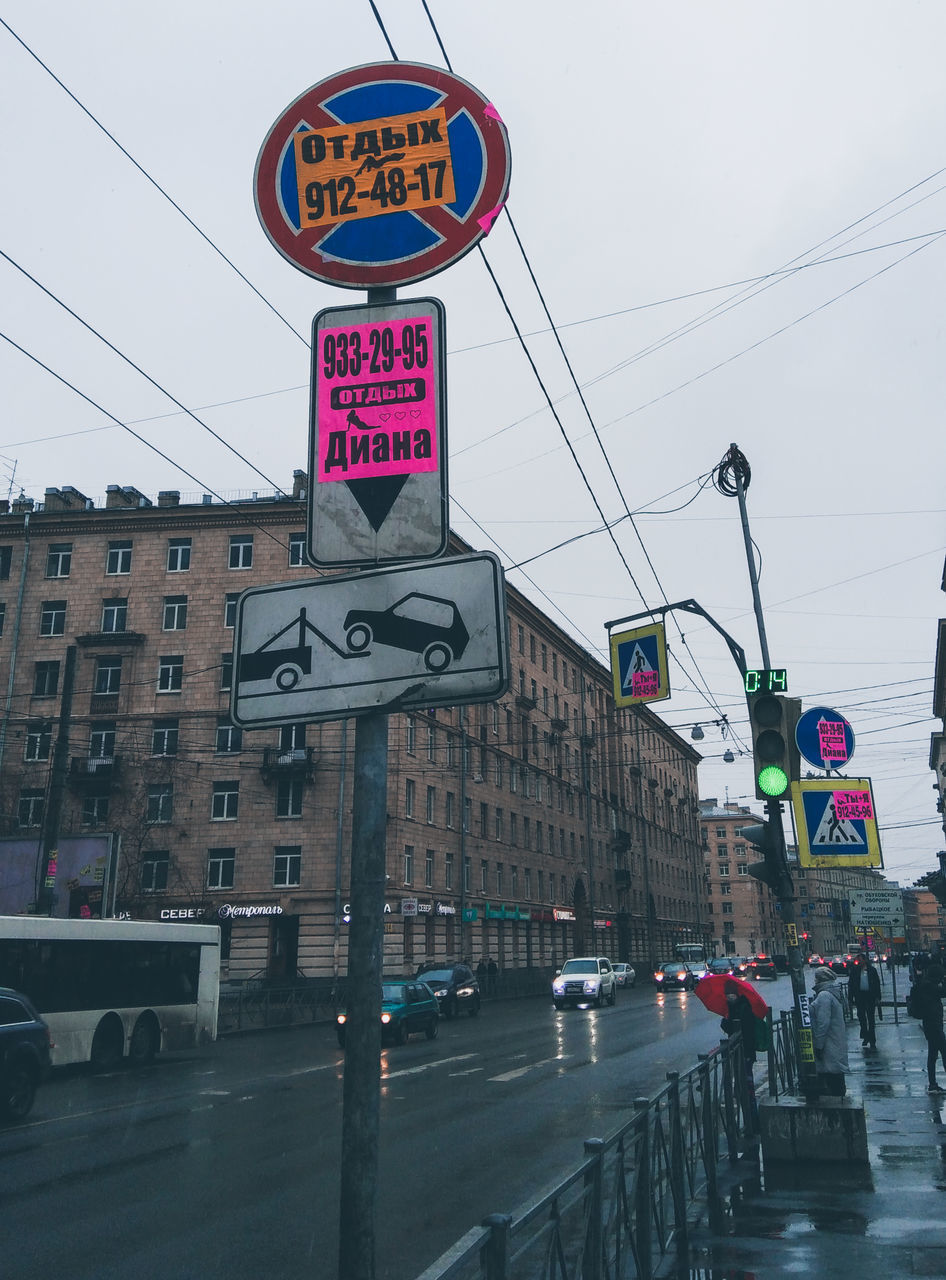 ROAD SIGN AGAINST SKY IN CITY