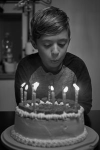 Boy blowing birthday candles on cake