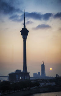 Tower and buildings against sky during sunset