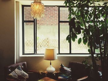 View of lamp on table against window